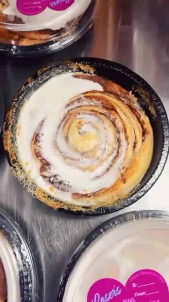 Breeden’s oversized cinnamon roll with thick frosting in its round black baking pan